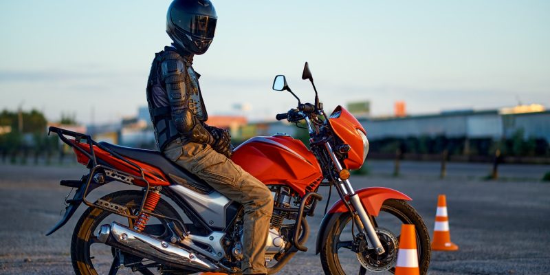 Male student poses on motorbike, motorcycle school